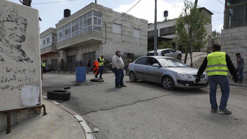 فلسطينيون يديرون نقطة لقياس درجة حرارة الناس عند مدخل قرية بالقرب من رام الله في الضفة الغربية المحتلة. 6 أبريل 2020. (عباس مومني/ أ ف ب)