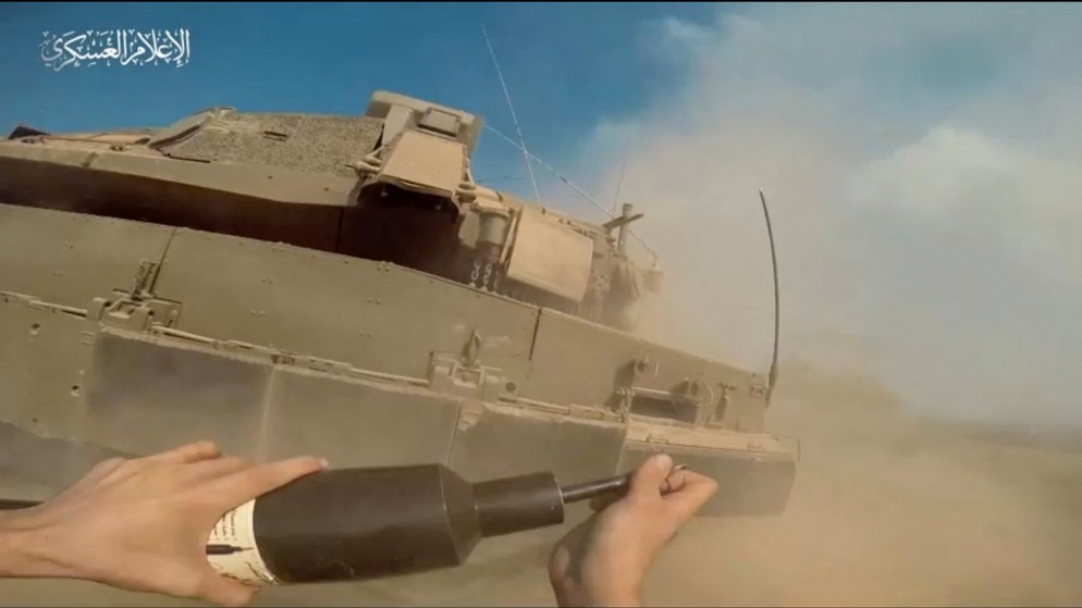 صورة من مقطع فيديو نشرته كتائب القسام تظهر مقاتلا يضع عبوة ناسفة على دبابة إسرائيلية في قطاع غزة. 2 تشرين الثاني 2023. (رويترز)