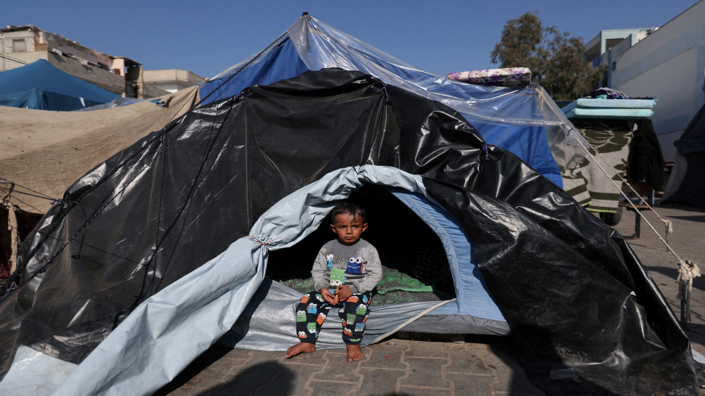 طفل فلسطيني يجلس في خيمة في خان يونس بعد أن اضطرت عائلته مع مئات آلاف الفلسطينيين للنزوح من منازلهم هربا من غارات عنيفة للاحتلال الإسرائيلي على قطاع غزة المحاصر. (رويترز)