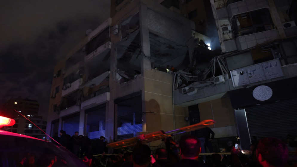 أشخاص يتجمعون في موقع غارة، أفادت وسائل إعلام لبنانية أنها غارة إسرائيلية استهدفت مكتبا لحركة حماس، في الضاحية الجنوبية لبيروت، 2 يناير، 2024. (أ ف ب)