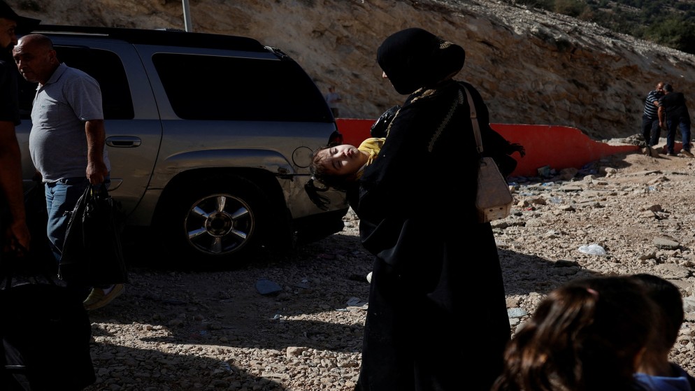 أشخاص يسيرون على متن حافلة قدمها الهلال الأحمر العربي السوري، بعد العبور من لبنان إلى سوريا سيرا على الأقدام عند معبر المصنع الحدودي. 14 أكتوبر/تشرين الأول 2024. (رويترز)