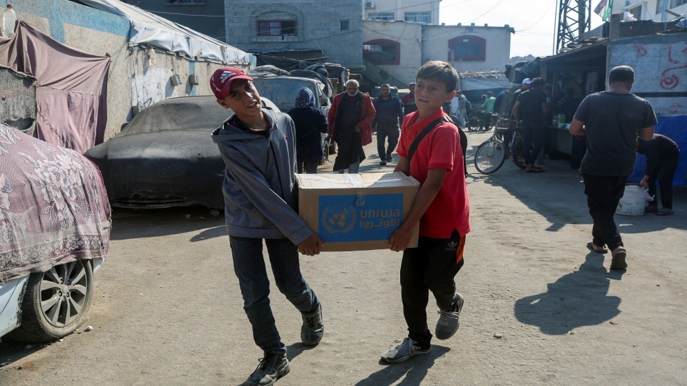 أطفال فلسطينيون يحملون صندوق مساعدات وزعته وكالة الأمم المتحدة لإغاثة وتشغيل اللاجئين (أونروا) في دير البلح، 4 نوفمبر 2024. (رويترز)