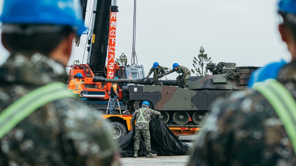 جنود من الجيش التايلاندي يقومون بتأمين دبابة قتال أميركية الصنع من طراز M1A2 Abrams على مقطورة في مركز تدريب مدرعات الجيش. (أ ف ب)