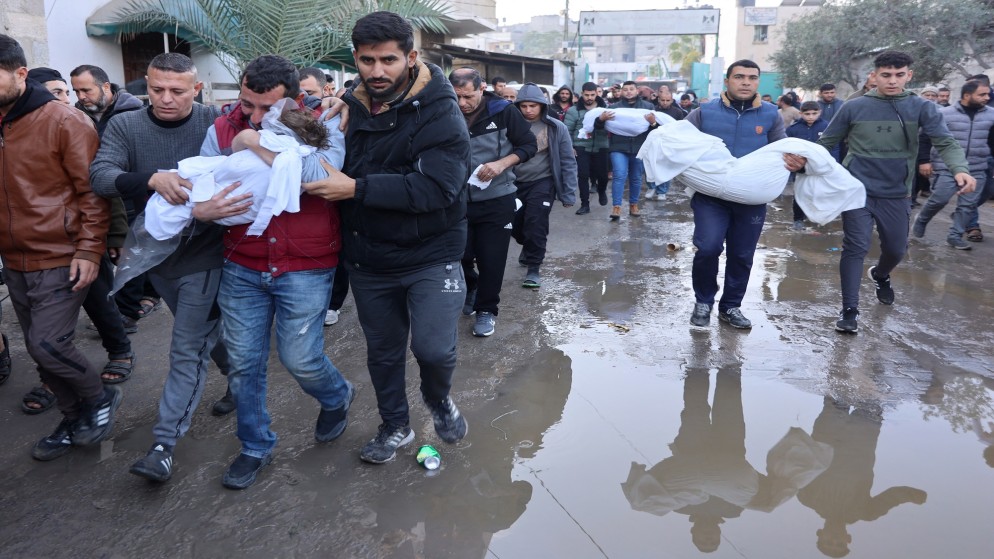 فلسطينيون يحملون شهداءهم في جباليا، شمال قطاع غزة.21 ديسمبر 2024،(أ ف ب)