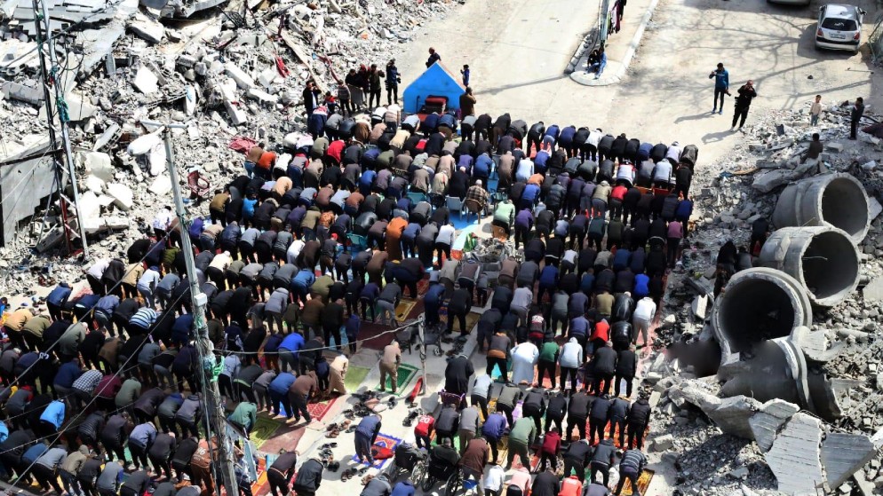 فلسطينيون يؤدون الصلاة أمام أنقاض مسجد الفاروق في رفح. (وفا)