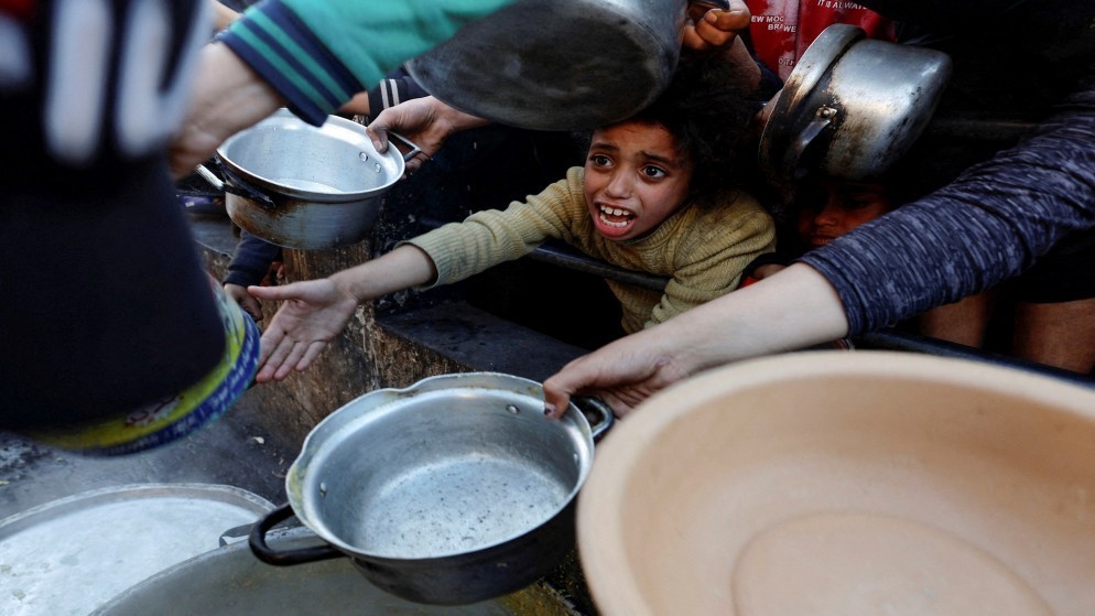 فلسطينيون ينتظرون الحصول على الطعام خلال شهر رمضان المبارك، في رفح جنوب قطاع غزة، 13 آذار/ مارس 2024. (رويترز)