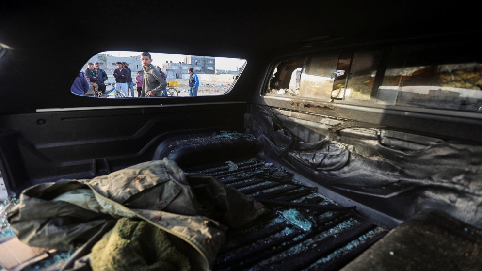 فلسطينيون ينظرون من نافذة مركبة مدمرة بعد غارة إسرائيلية أدت إلى مقتل عمال إغاثة في منظمة المطبخ المركزي العالمي. (رويترز)