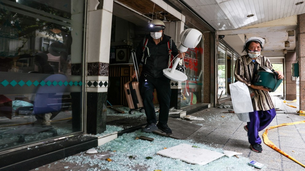 السكان ينقذون ممتلكاتهم من مبنى تونغشواي المتضرر في أعقاب زلزال 3 أبريل في مدينة هوالين في 5 أبريل 2024.(أ ف ب)