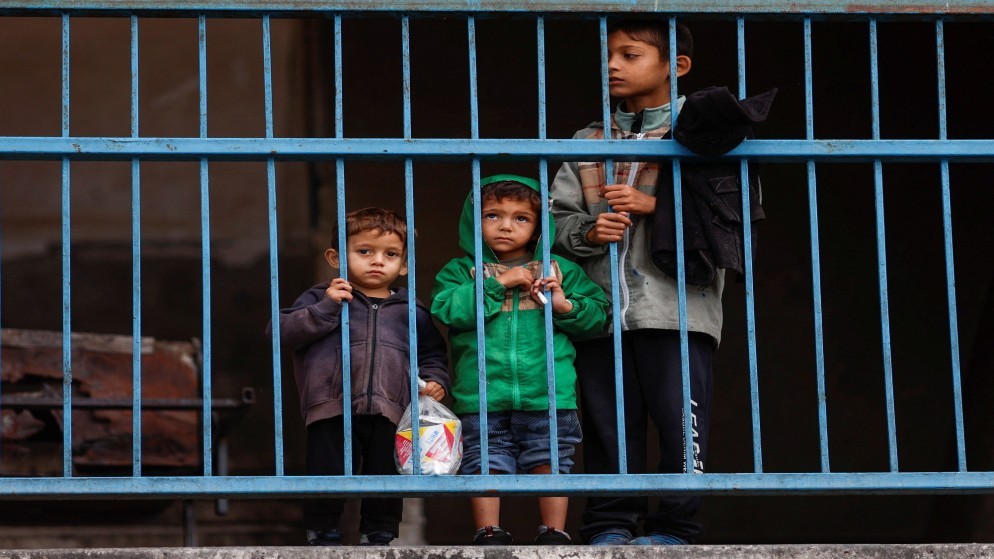 أرشيفية لأطفال فلسطينيين نازحين يقفون في مدرسة قبل الفرار من رفح بعد عدوان بري إسرائيلي في الجزء الشرقي من جنوب مدينة غزة. 13/011/2024. (رويترز)