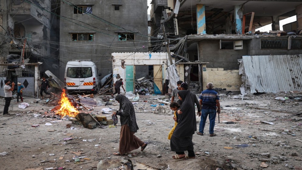 فلسطينيون ينظرون إلى أنقاض منزل عائلي تعرض للقصف الإسرائيلي جنوبي قطاع غزة. رفح. 20 أيار/مايو 2024. (أ ف ب)