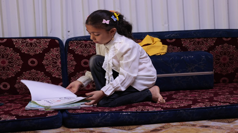 غزل (8 سنوات) من درعا تحضر دروسها وتتخوف من إغلاق المدارس في مخيم الأزرق للاجئين السوريين. (صلاح ملكاوي/ المملكة)
