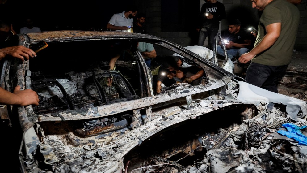 فلسطينيون يتفقدون سيارة مدمرة في أعقاب عملية عسكرية إسرائيلية في قباطية بالقرب من جنين بالضفة الغربية التي تحتلها إسرائيل .13 يونيو 2024. (رويترز)