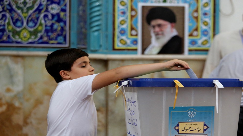 صبي إيراني يضع ورقة اقتراع في صندوق اقتراع في طهران خلال الانتخابات الرئاسية الإيرانية، 28 حزيران/يونيو 2024. (أ ف ب)