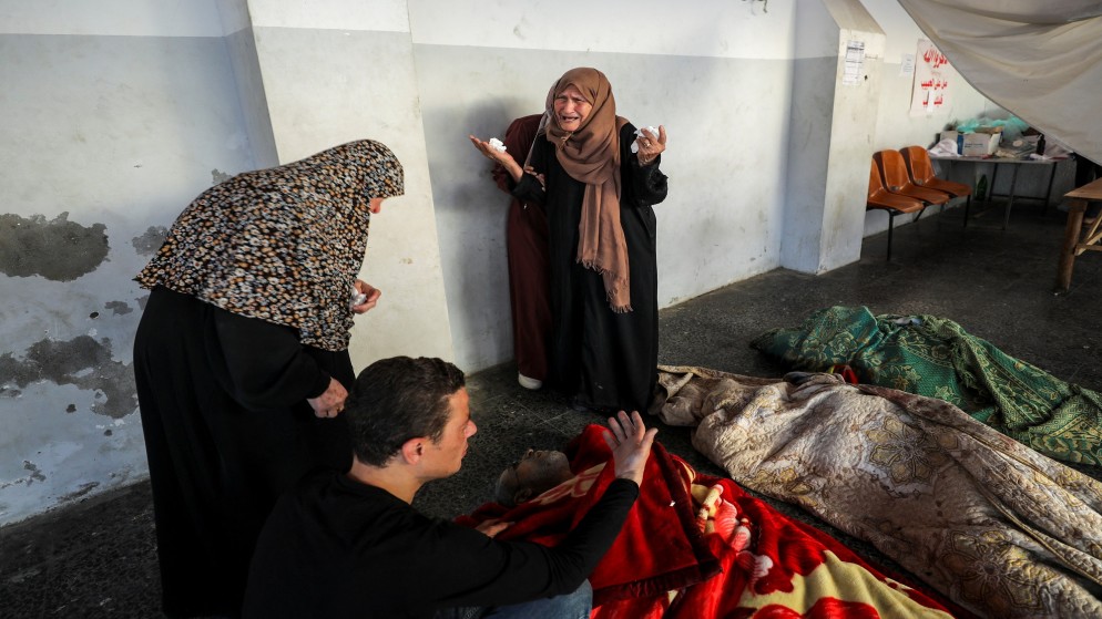 فلسطينيون بالقرب من جثامين شهداء في المستشفى الأهلي العربي في مدينة غزة. 25 يونيو، 2024. (رويترز)
