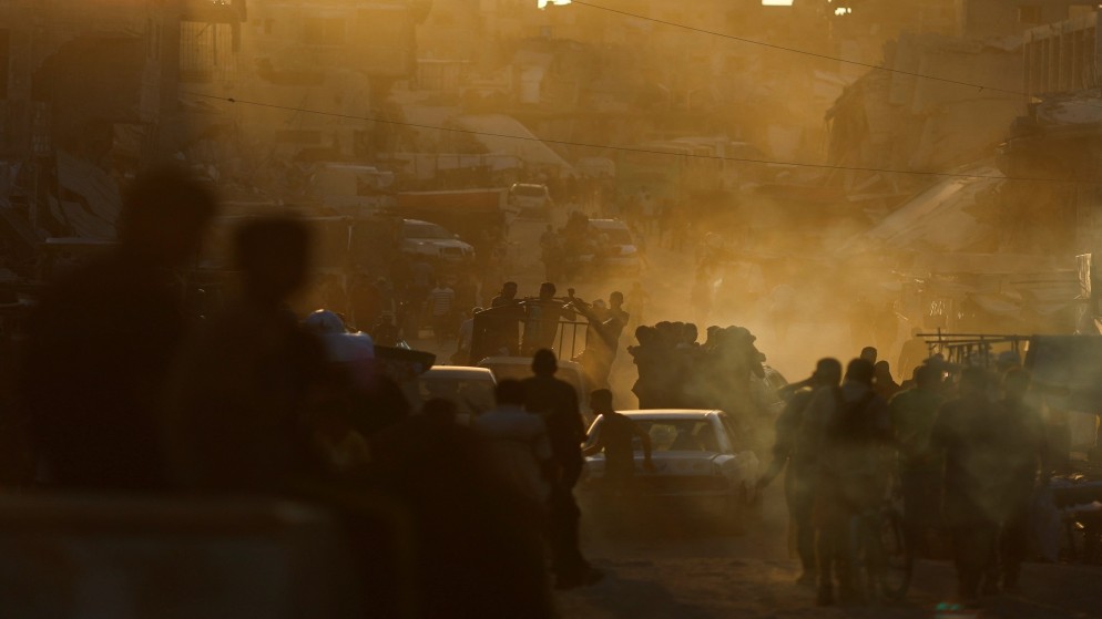 فلسطينيون يسيرون عند بقايا سوق دمرته غارة للاحتلال الإسرائيلي في خان يونس جنوبي قطاع غزة. 30/06/2024. (رويترز)