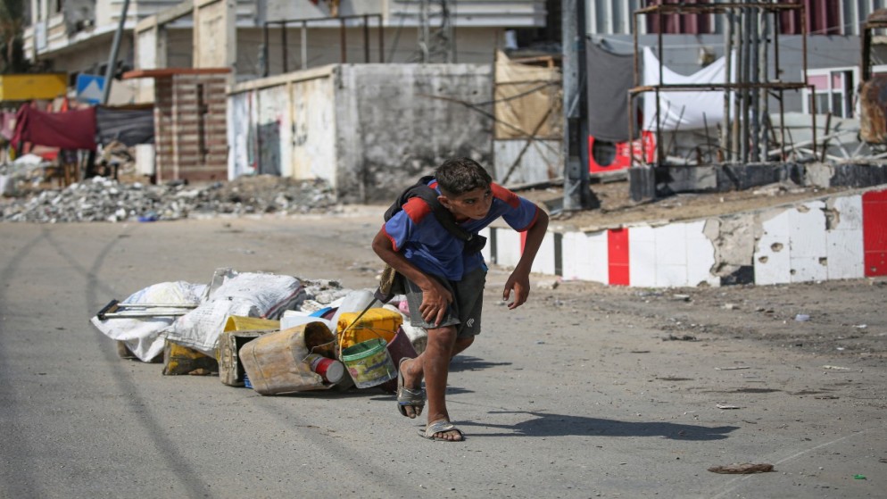 فلسطيني يسحب بعض الأشياء التي تم إنقاذها في دير البلح وسط قطاع غزة ،27 آب 2024. (أ ف ب)