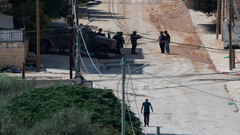 جندي إسرائيلي يصوب سلاحه نحو فلسطينيين في جنين في الضفة الغربية المحتلة، 31 آب/أغسطس 2024. (رويترز)