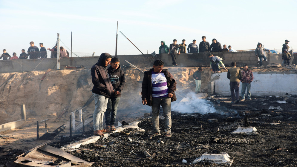 فلسطينيون يتفقدون موقع غارة إسرائيلية على مقهى على شاطئ البحر في دير البلح في وسط قطاع غزة، 14 كانون الثاني/ يناير 2025. (رويترز)