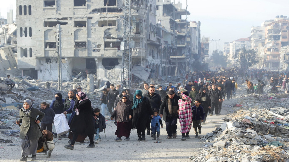 نازحون فلسطينيون يشقون طريقهم بين الأنقاض، وهم يحاولون العودة إلى منازلهم في شمال قطاع غزة، 19 كانون الثاني 2025. (رويترز)