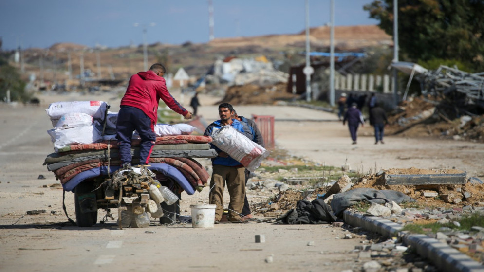 فلسطينيون نازحون بالقرب من حاجز في شارع صلاح الدين بالنصيرات، 25 يناير 2025. (أ ف ب)