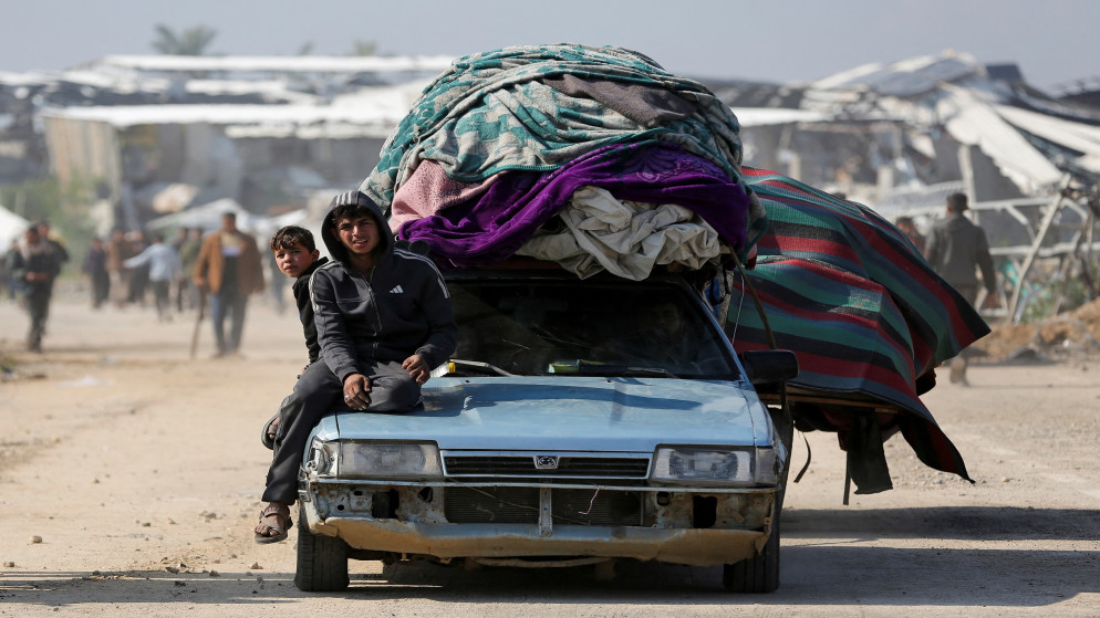 يجلس الناس على مركبة بينما ينتظر الفلسطينيون الذين نزحوا إلى الجنوب العودة إلى منازلهم في شمال غزة بالمركبات عبر طريق صلاح الدين، 27 يناير 2025. (رويترز)