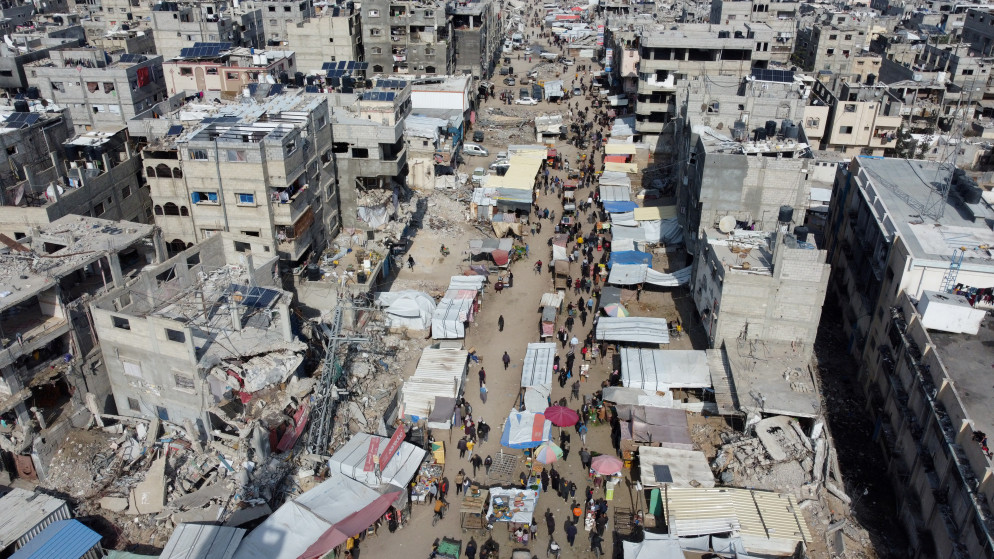 فلسطينيون يسيرون في أحد أسواق الشوارع في خان يونس في جنوب قطاع غزة، 19 كانون الثاني/ يناير 2025. (رويترز)