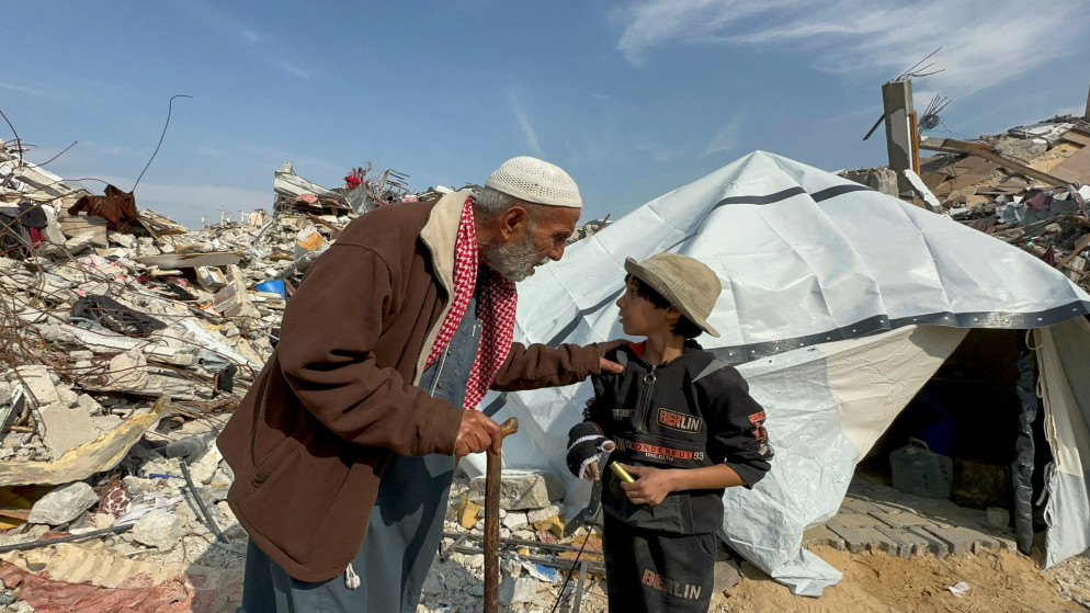 فلسطيني يتحدث مع طفل وسط الدمار في مخيم جباليا، 28 كانون الثاني 2025. (رويترز)