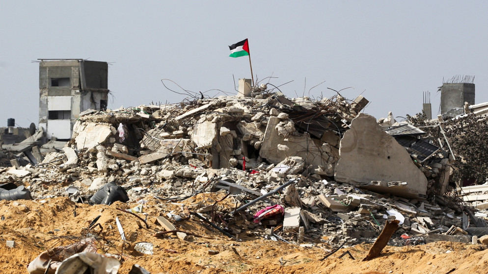 علم فلسطيني يرفرف بين أنقاض المباني المدمرة بسبب القصف الإسرائيلي في رفح جنوبي قطاع غزة، 4 فبراير/شباط 2025.(رويترز)