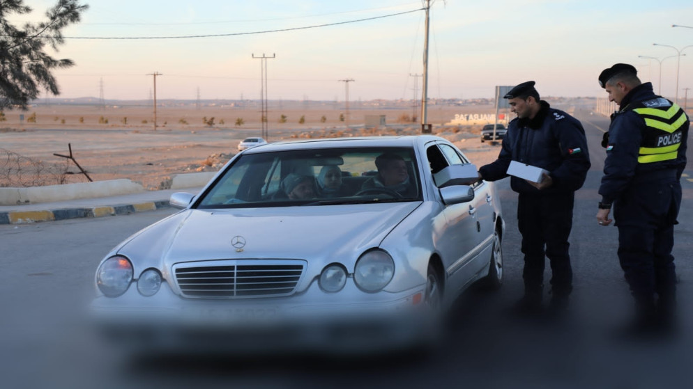 كوادر الدوريات الخارجية توزع وجبات خفيفة ومياه وتمور على السائقين خلال وقت الإفطار. (الأمن العام)