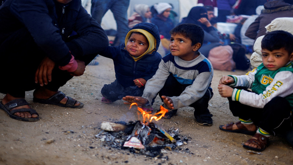 أطفال فلسطينيون ينتظرون السماح لهم بالعودة إلى منازلهم في شمال غزة بعد تهجيرهم إلى الجنوب بأمر الاحتلال أثناء الحرب، في وسط قطاع غزة، 26 يناير 2025. (رويترز)