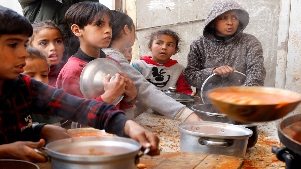 أطفال فلسطينيون ينتظرون الحصول على الطعام من جمعية خيرية في خان يونس. قطاع غزة. 9 مارس/آذار 2025. (رويترز)