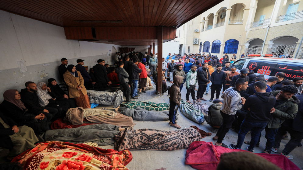 فلسطينيون بالقرب من جثامين الشهداء جراء الغارات الإسرائيلية في مستشفى بمدينة غزة، 18 آذار 2025. ( رويترز)