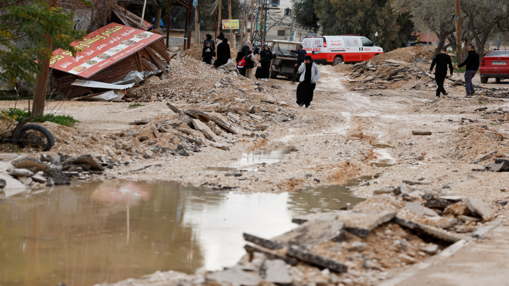 فلسطينيون يسيرون في شارع متضرر في مخيم جنين في الضفة الغربية المحتلة، 23 كانون الثاني 2025. (رويترز)