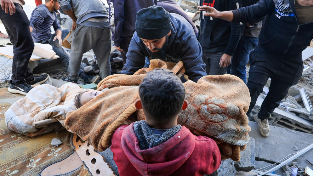 رجل يحمل جثة طفل فلسطيني استشهد في غارة إسرائيلية على مبنى سكني في مدينة غزة، 19 آذار 2025. (رويترز)