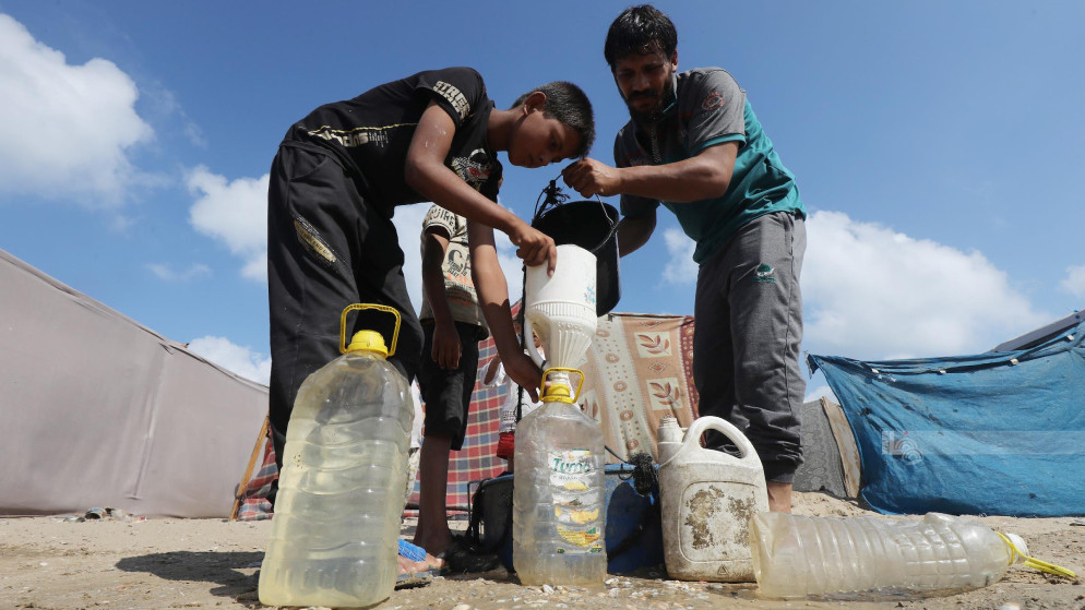 فلسطينيون في غزة يعبئون المياه. (وفا)